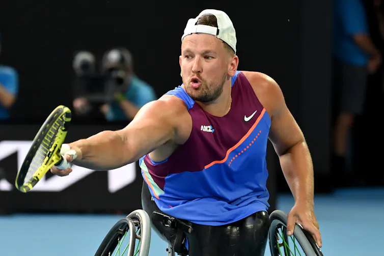 man hits tennis ball in wheelchair