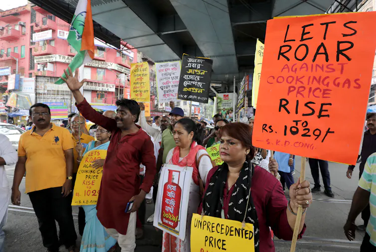 Protesters carry signs highlighting the soaring price of LPG.