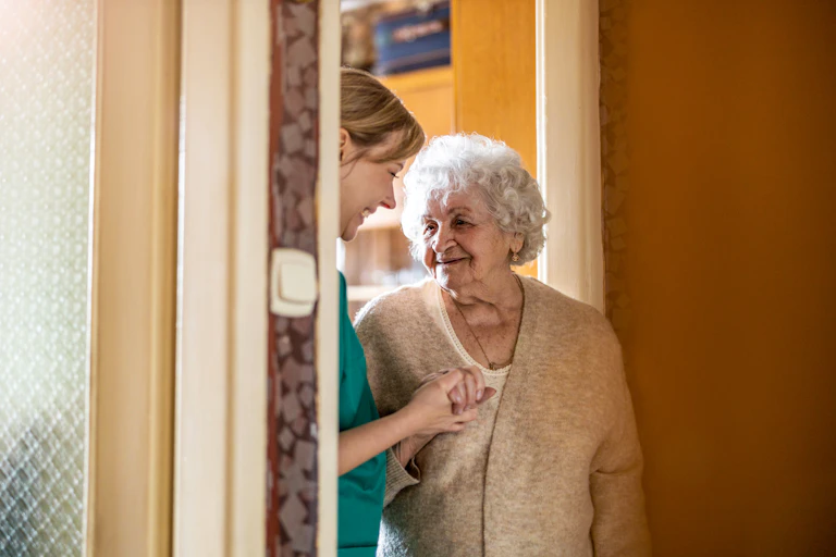 Photo d’une femme âgée chez elle avec une soignante