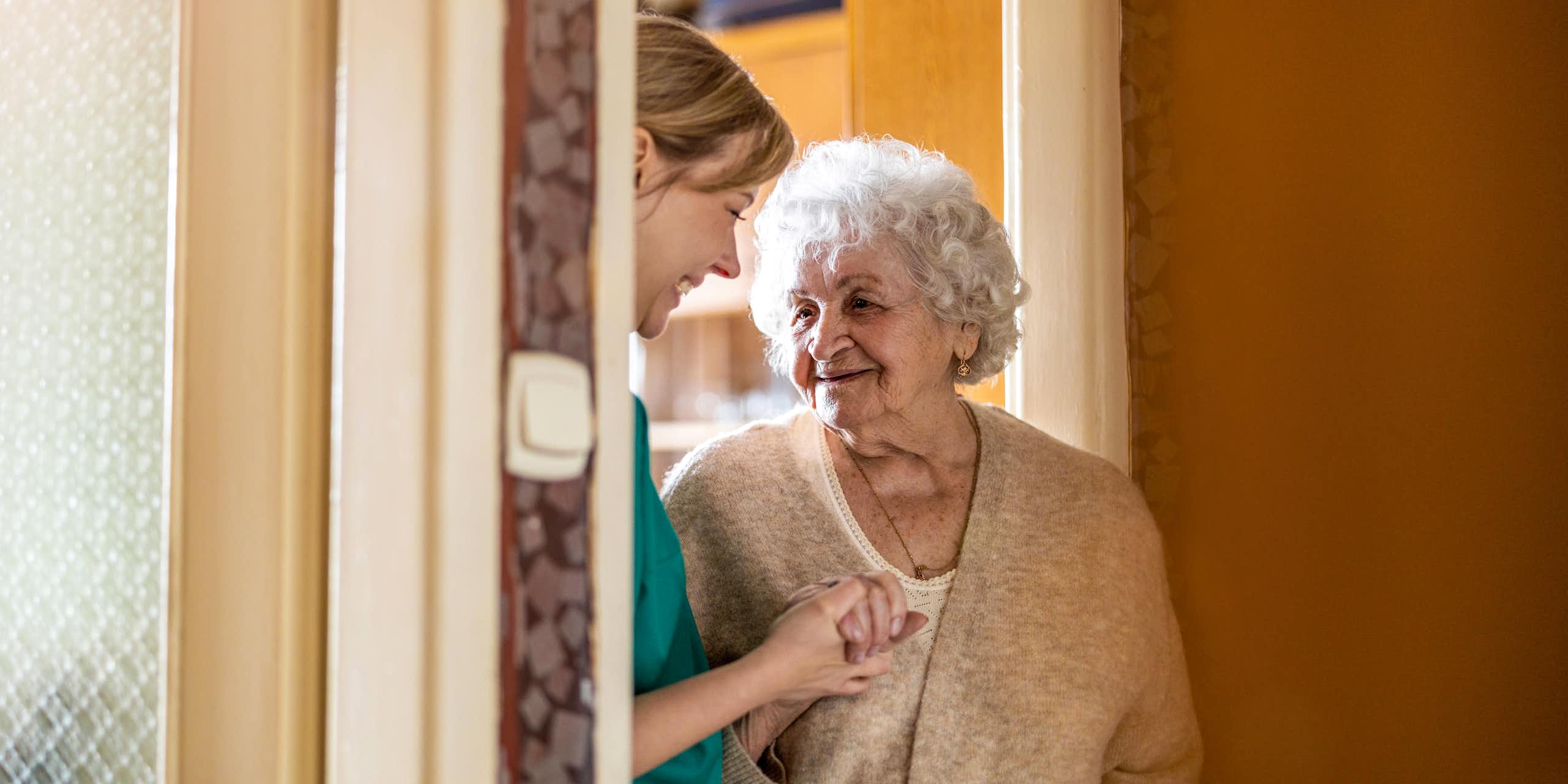Photo d’une femme âgée chez elle avec une soignante