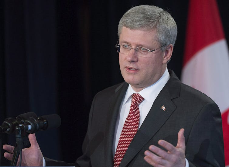 A man in a suit gesturing while he speaks