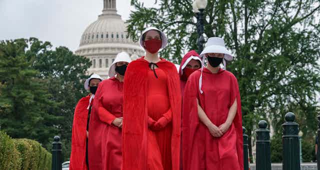 Women dresses in long red cloaks and red bonnets seen in front of Capitol Hill in Washington.