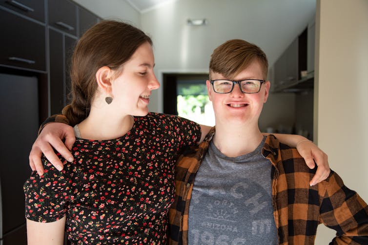 Young woman and man hug side by side.