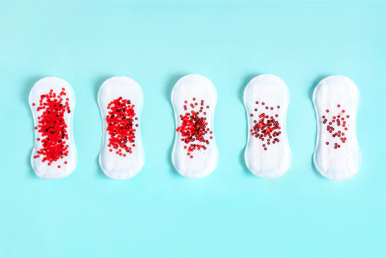 series of menstrual pads with red sequins to represent blood flow