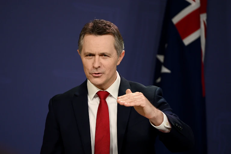 Man in suit and tie gestures while speaking