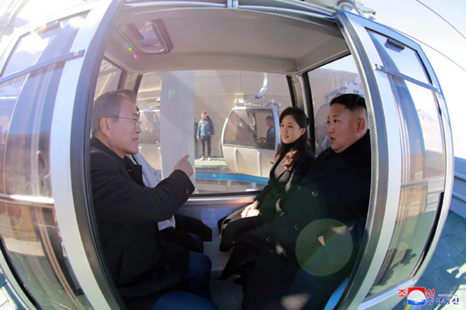 Two men in a cable car talking.