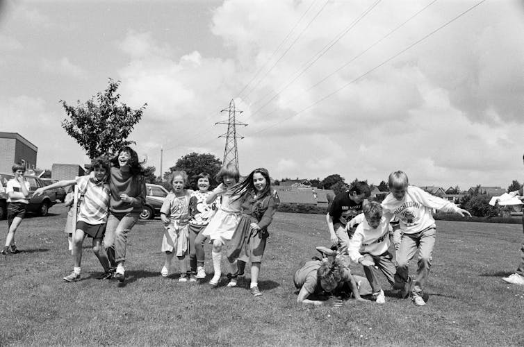 School pupils compete in a three-legged race in a Church of England school summer fête.