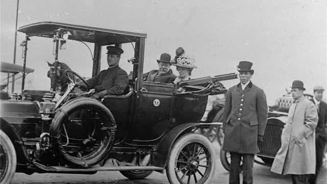 President William Howard Taft and his wife ride in a car.