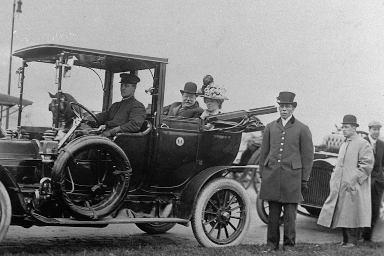 President William Howard Taft and his wife ride in a car.