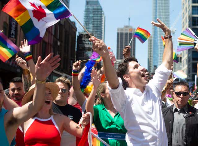 People wave rainbow flags in a pride parade