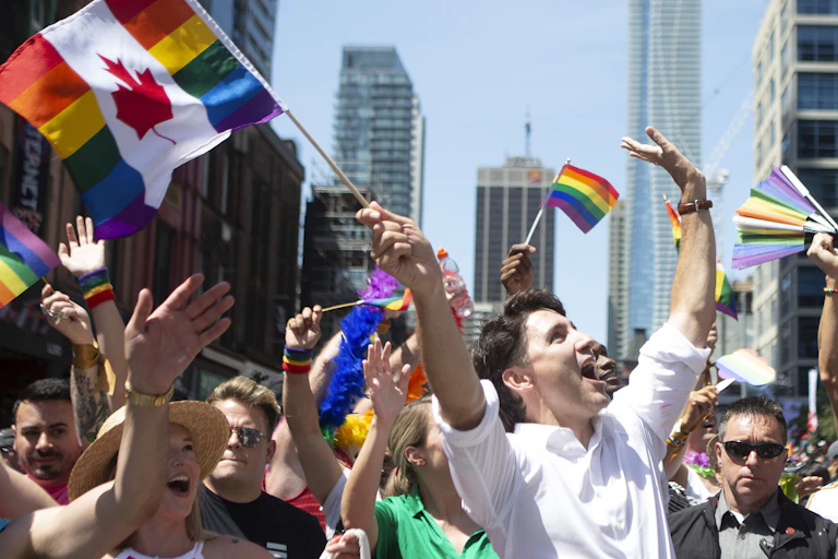 People wave rainbow flags in a pride parade