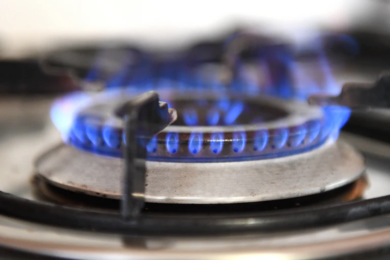 A gas burner burns on a stove.