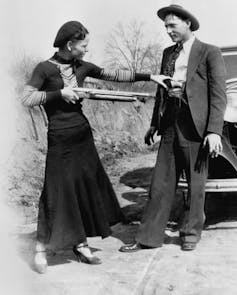 Photo of infamous outlaws Bonnie and Clyde, with her pointing a gun at him in jest
