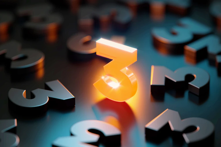 a three-dimensional glowing orange numeral three standing perpendicular on a surface covered with metallic three-dimensional numeral threes
