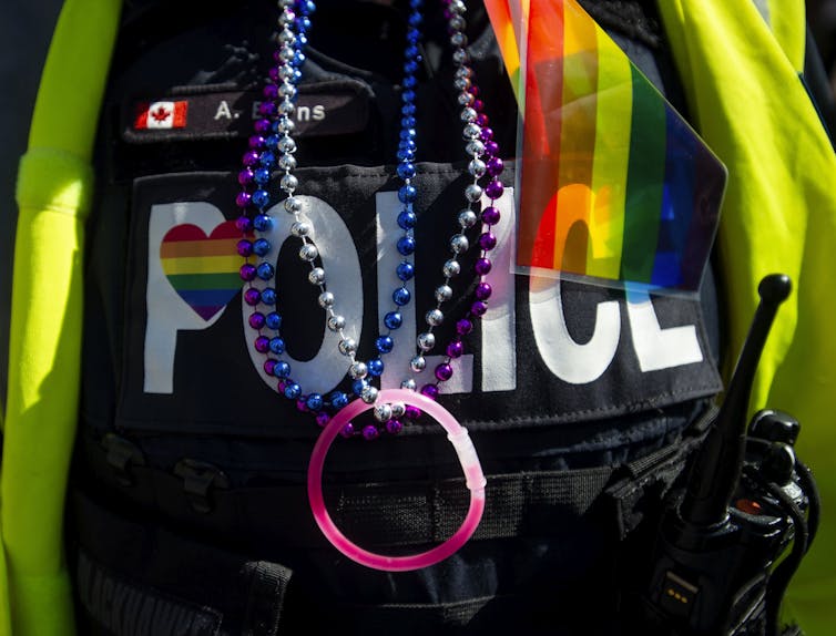 A close up of a police uniform with a red rainbow flag on it