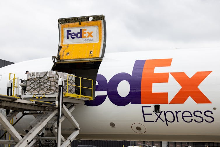 A FedEx pane is seen with a cargo shipment of baby formula being unloaded.