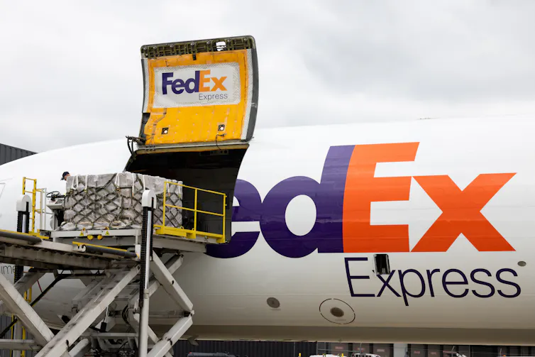 A FedEx pane is seen with a cargo shipment of baby formula being unloaded.