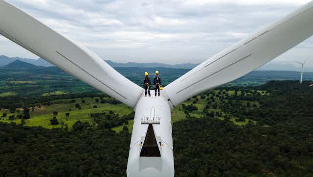 two people on top of wind turbine