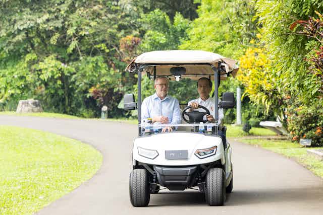 Indonesian President Joko Widowi takes Prime Minister Anthony Albanese for a ride in a cart.