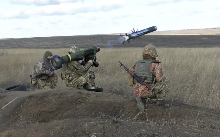 a javelin missile is fired from a rocket launcher held on the shoulder of a ukrainian soldier standing in a field in donetsk as another solider looks on