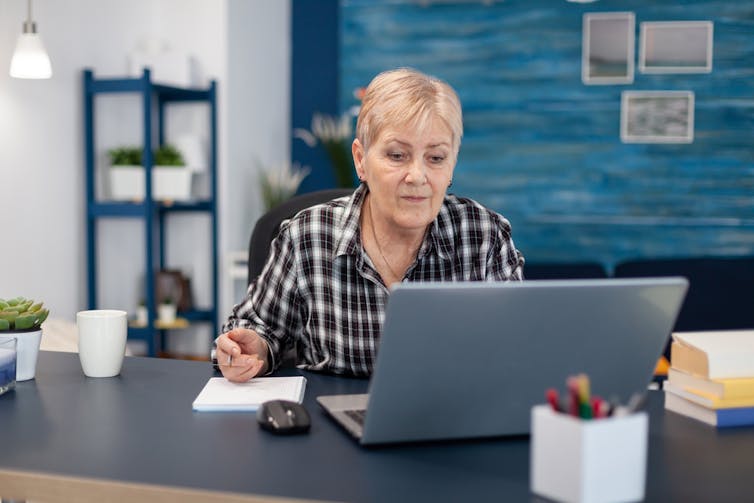 Woman sitting at the computer and taking notes