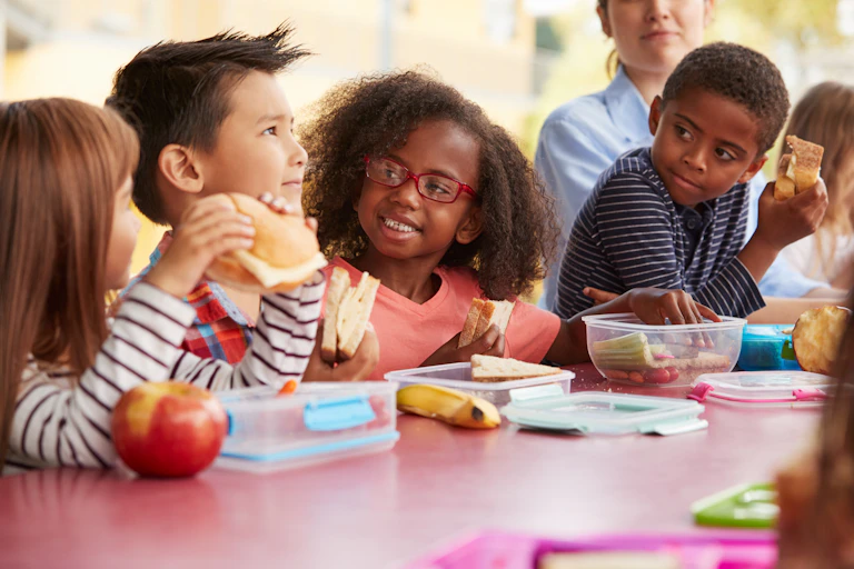 Children seated at a table eating lunch