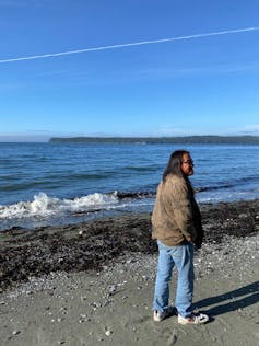 a man stands by the water