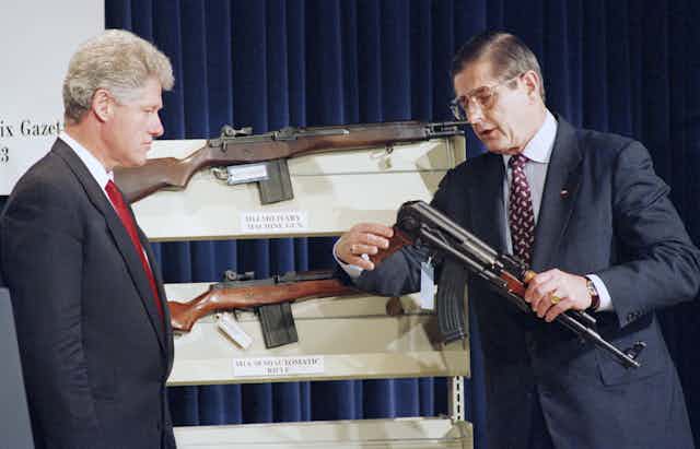 President Bill Clinton looks on as Bureau of Alcohol, Firearms and Tobacco Director John Magaw holds a AK-47.