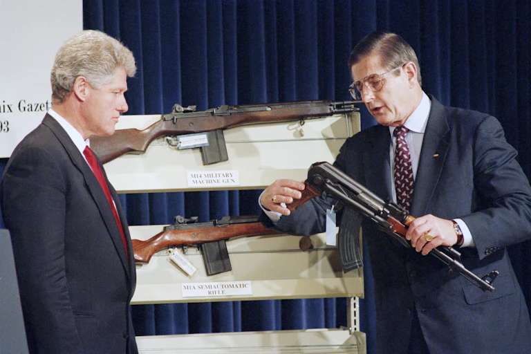 President Bill Clinton looks on as Bureau of Alcohol, Firearms and Tobacco Director John Magaw holds a AK-47.