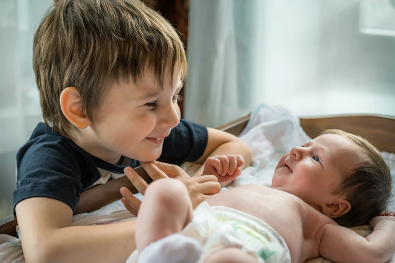 little boy and baby look at each other's faces