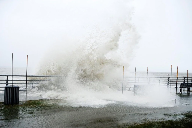grande vague déferlant sur une promenade au bord de la mer