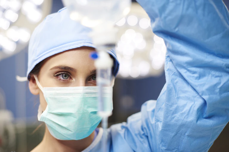 Anesthesiologist holding up IV drip