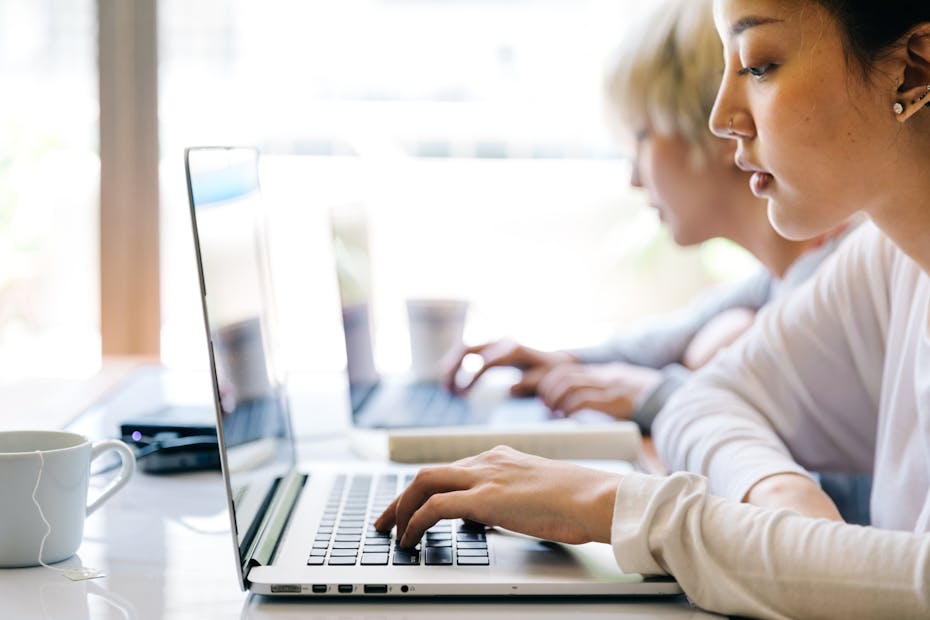 Women are seen sitting at laptops.