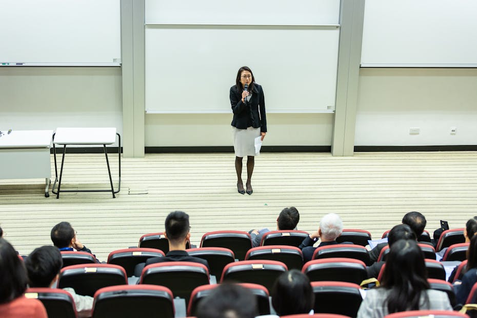 A professor stands at the front of a room.