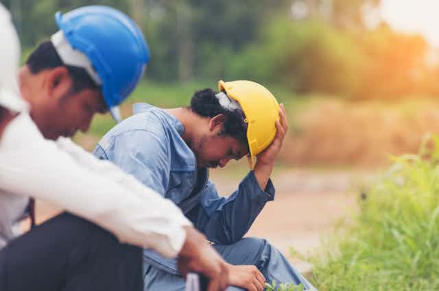 Exhausted construction workers taking break