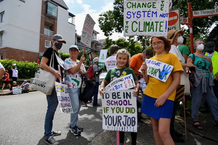 Protesting students hold up placards