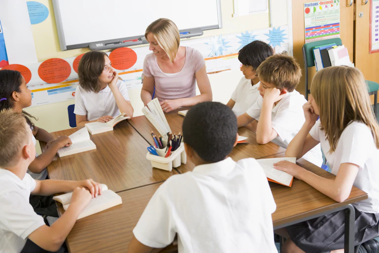 Teacher discusses a book being read by a group of students sitting around a table