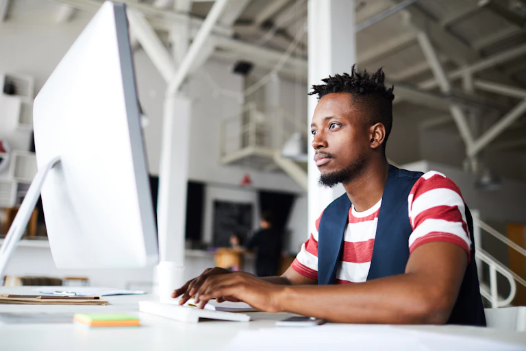 A young man working at a computer.