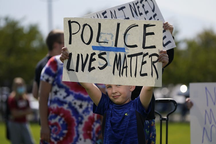 A boy holds a sign reading Police Lives Matter