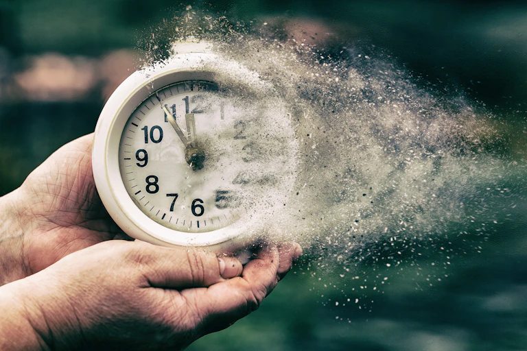 A pair of hands hold a disintegrating white round clock