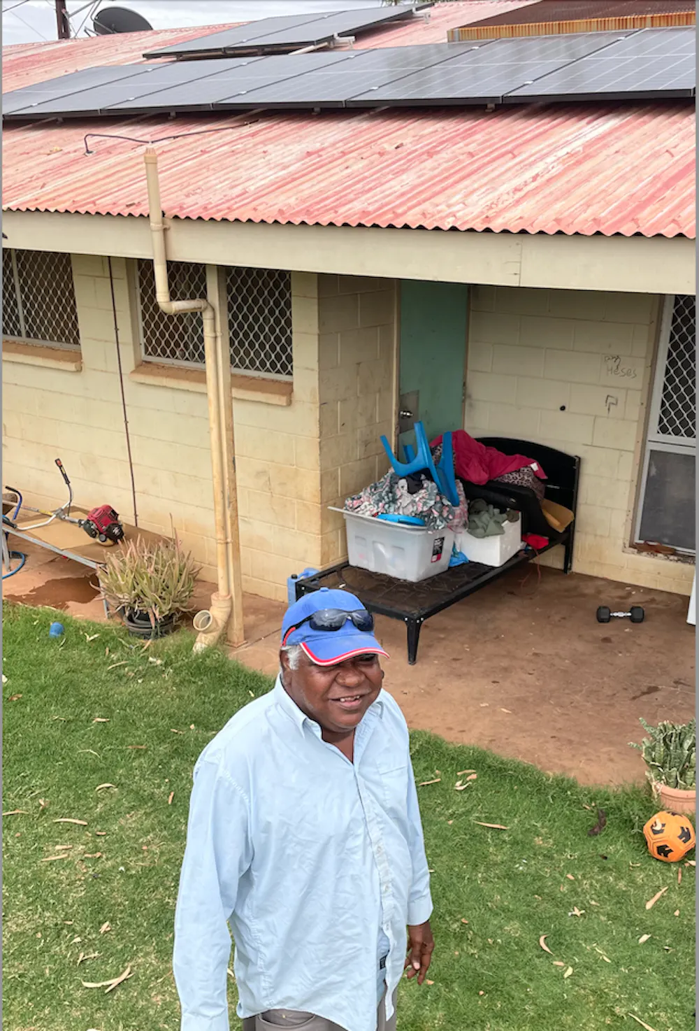 Norman Frank Jupurrurla outside his house, with rooftop solar panels