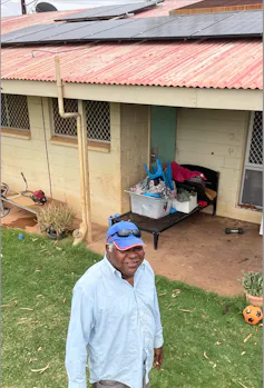 Norman Frank Jupurrurla outside his house, with rooftop solar panels