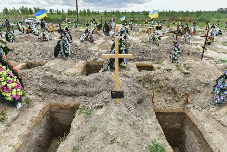 Graveyard in Bucha, Kyiv, May 2022 with freshly dug graves in the foreground.
