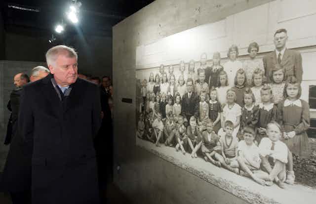 Horst Seehofer, president of Bavaria, looks at a picture of the inhaitants of Lidice taken before the whole town was wiped out on Ju