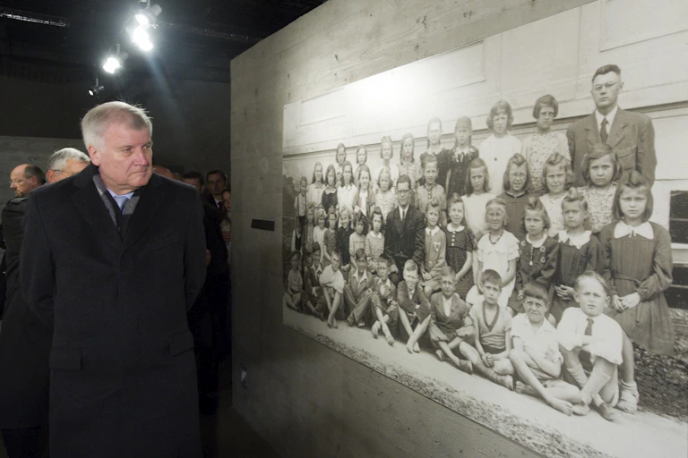 Horst Seehofer, president of Bavaria, looks at a picture of the inhaitants of Lidice taken before the whole town was wiped out on Ju