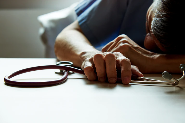 Un médecin épuisé semble endormis sur son bureau