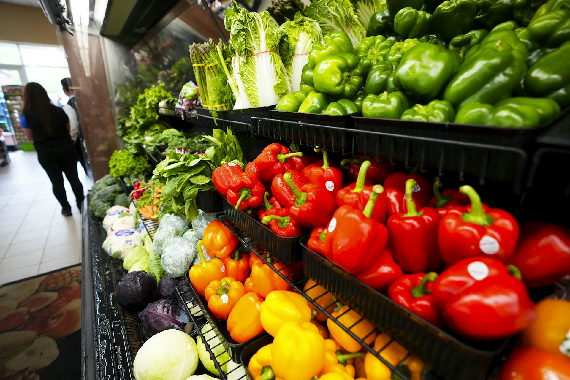 Fresh vegetables on a rack in a grocery store aisle
