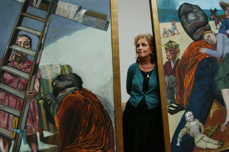 Paul Rego standing between two of her paintings.