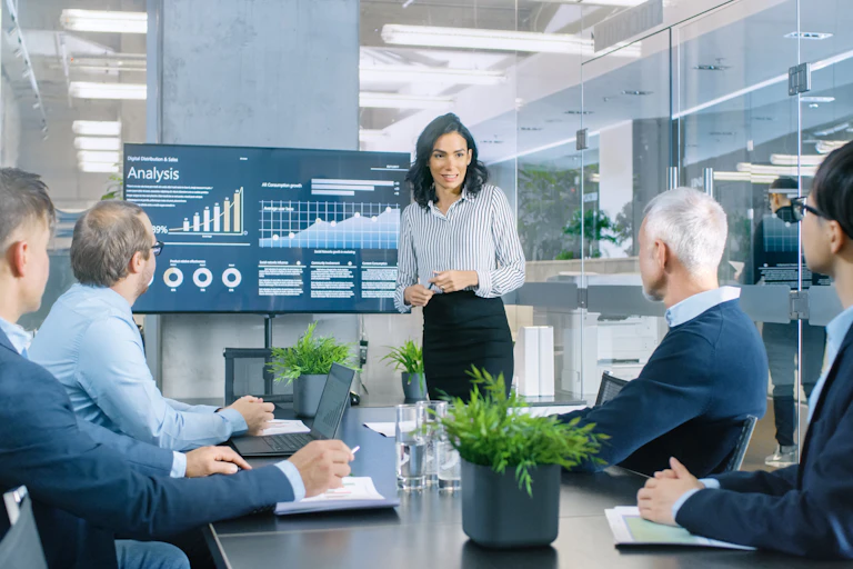 Woman presenting a financial analysis to 4 male colleagues