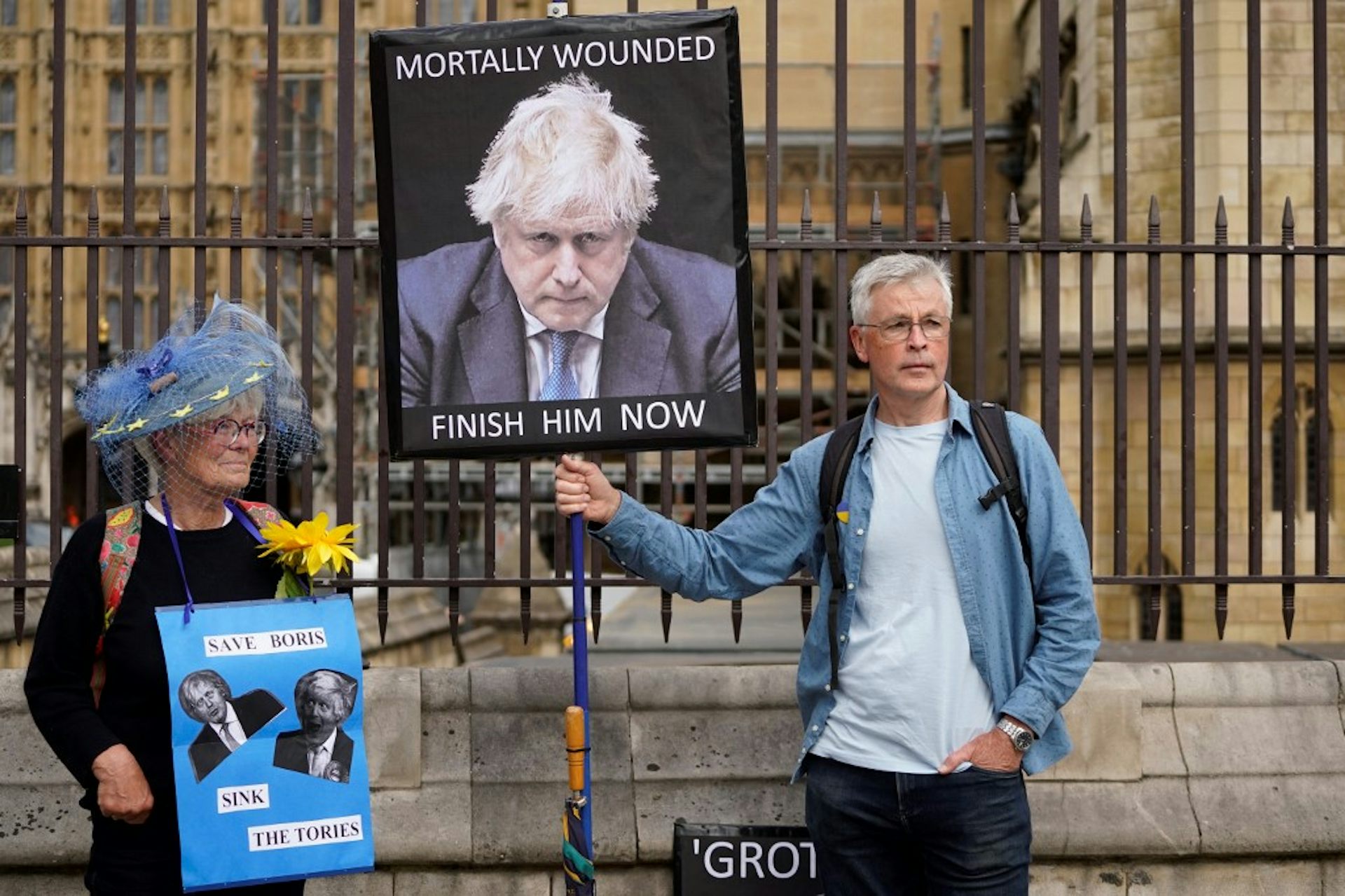 Une femme et un homme manifestent avec des slogans anti-Boris Johnson